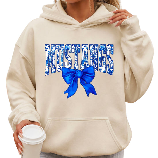 Mustangs floral bow hoodie for women in sand, varsity MUSTANGS letters with blue and white floral print and royal blue bow, image 1