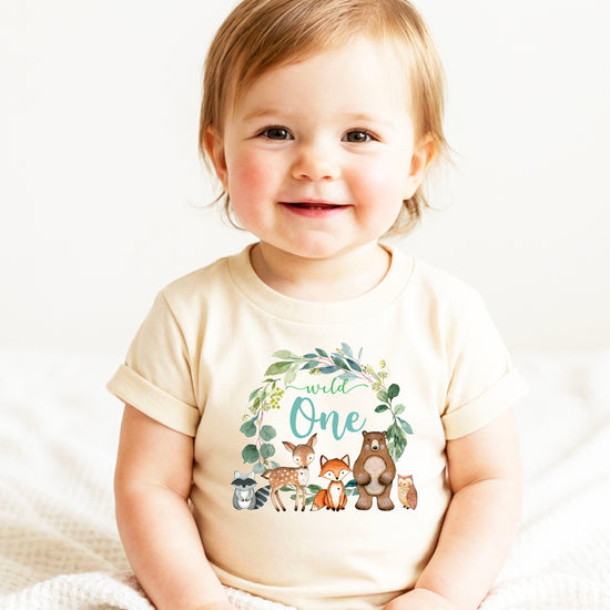 Close-up of Wild One woodland wreath design on natural baby tee