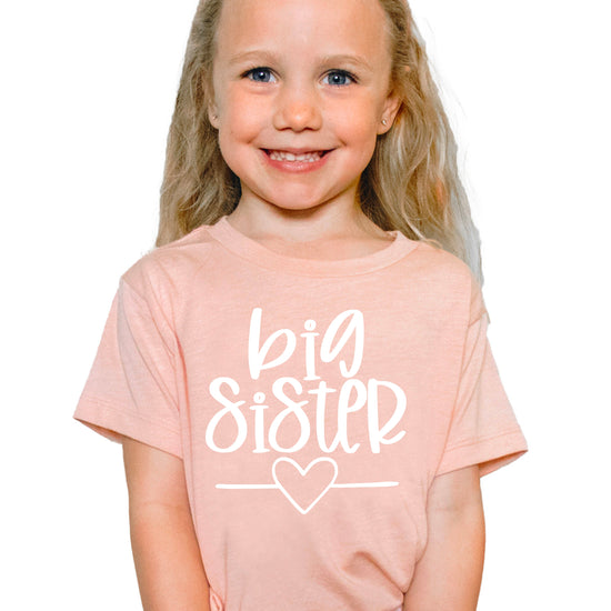 Big Sister heart sibling reveal t-shirt in white on peach, main view