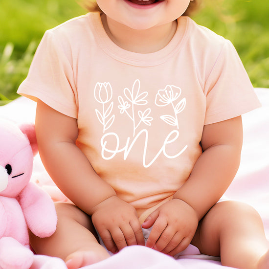 Floral One first birthday shirt for baby girls in white on peach, fourth view