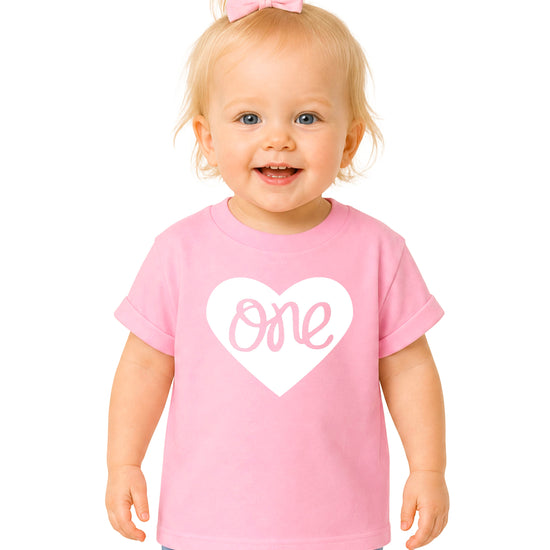 One in a Heart girls first birthday shirt, White on Pink, main product photo