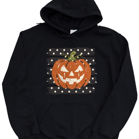 Black hoodie with retro polka dot jack o lantern pumpkin graphic, close-up of the graphic