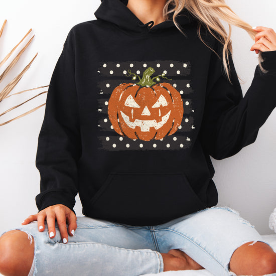 Black hoodie with retro polka dot jack o lantern pumpkin graphic, detail shot