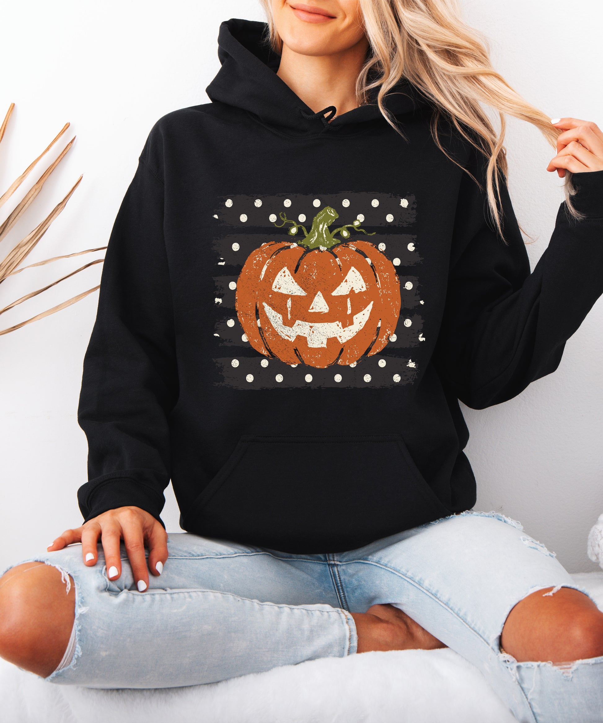 Black hoodie with retro polka dot jack o lantern pumpkin graphic, detail shot