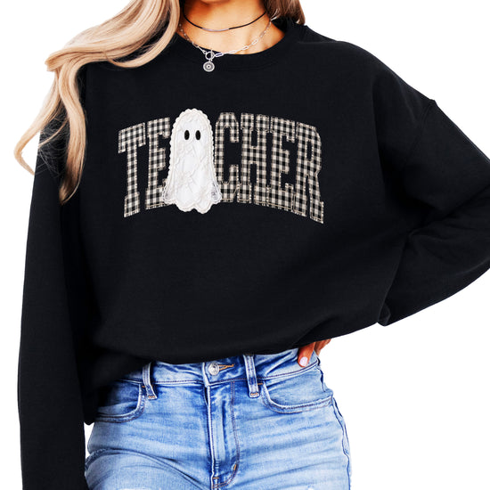 Black crewneck sweatshirt with ink-printed gingham checkered TEACHER lettering and lace-look ghost, front view