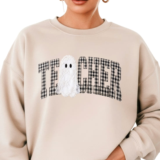 Sand crewneck sweatshirt with ink-printed gingham checkered TEACHER lettering and lace-look ghost, front view
