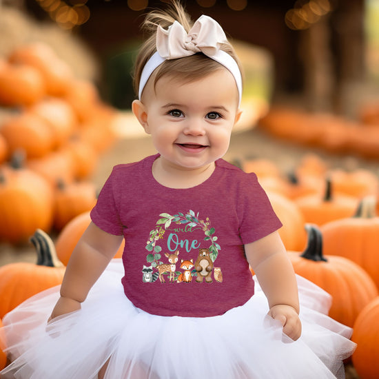 Close-up of Wild One woodland wreath design on vintage burgundy baby tee