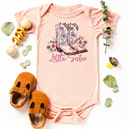 Peach Little Sister bodysuit, styled flat lay