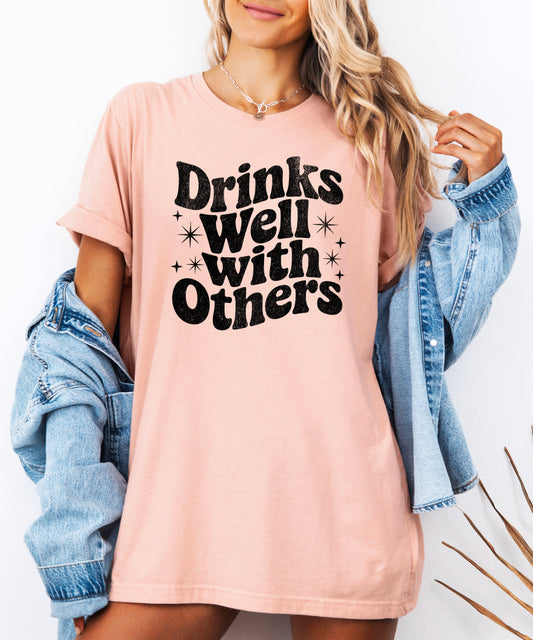 Drinks Well With Others funny graphic tee for women in Peach, back view
