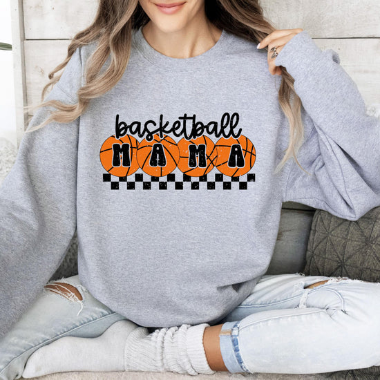 Model wearing white basketball mama crewneck sweatshirt with orange checkered design