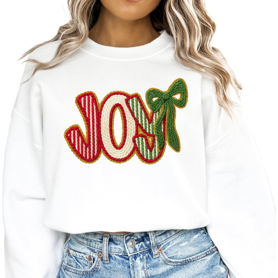 Flat lay of women's JOY holiday sweatshirt with Christmas graphic print detail