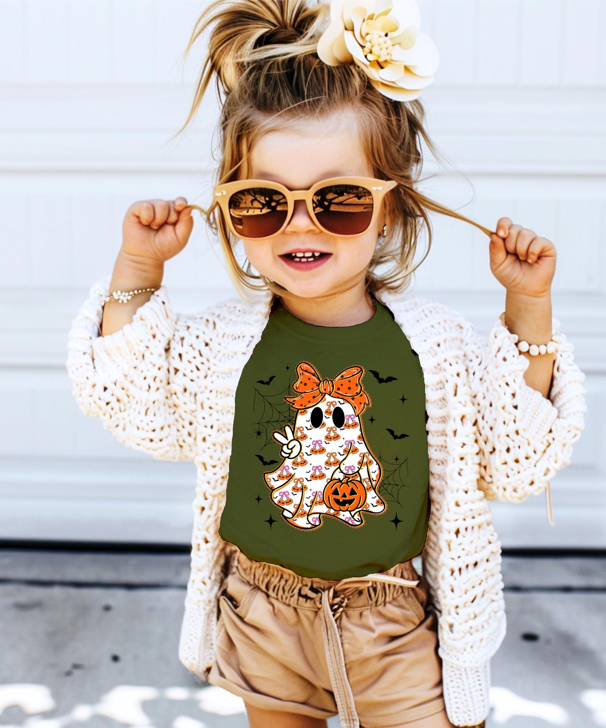 Detail shot of the ghost and orange bow graphic on a soft natural cotton kids Halloween shirt