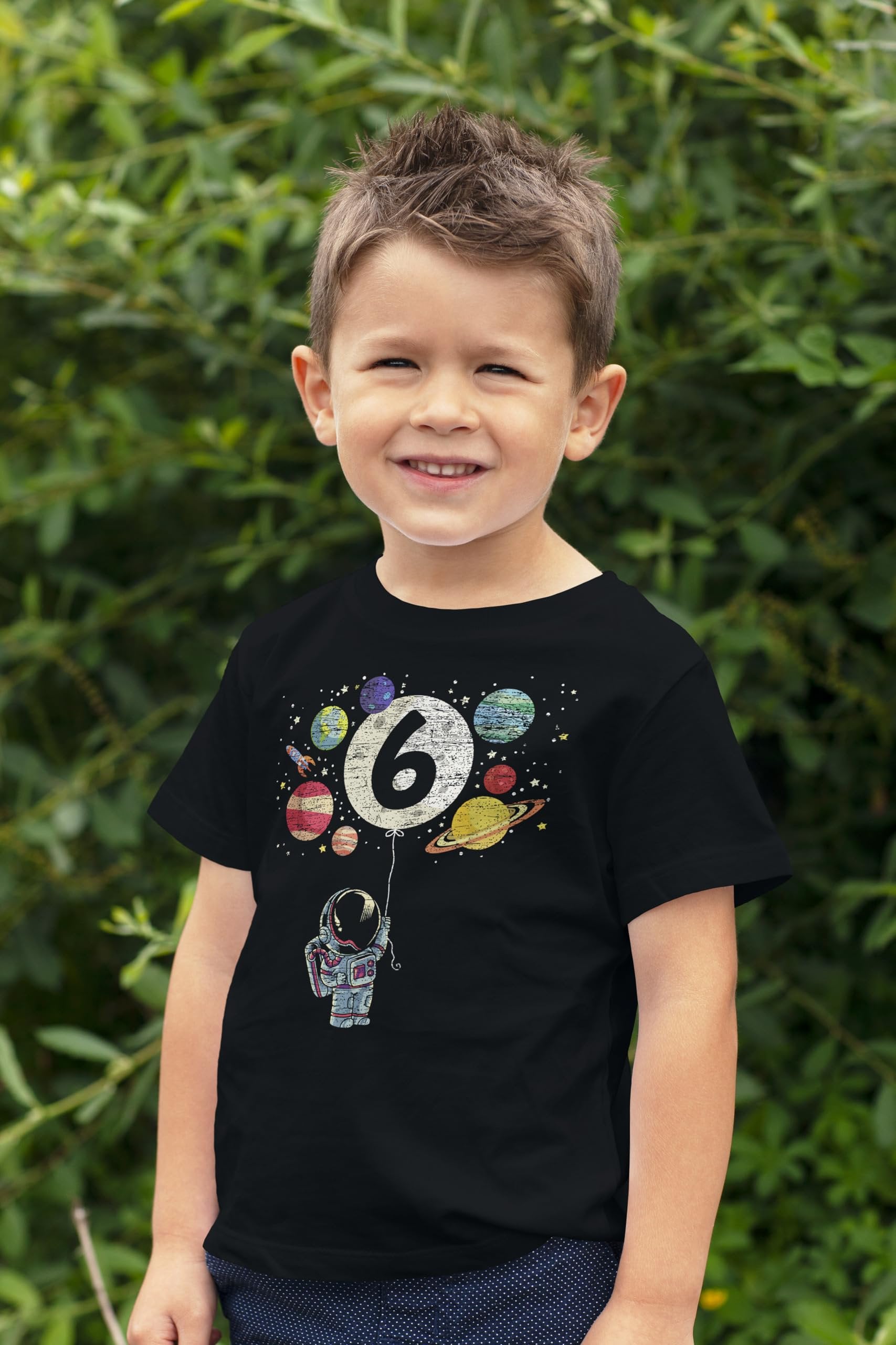 Child wearing 6th birthday space shirt with moon balloon and colorful planet graphics