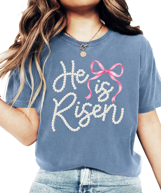 Front view of He Is Risen Christian shirt for women featuring pearl bow faith graphic on light tee