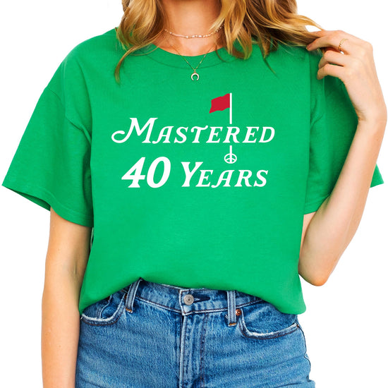 Flat lay of funny 40th birthday golf shirt showing full design and vintage green color