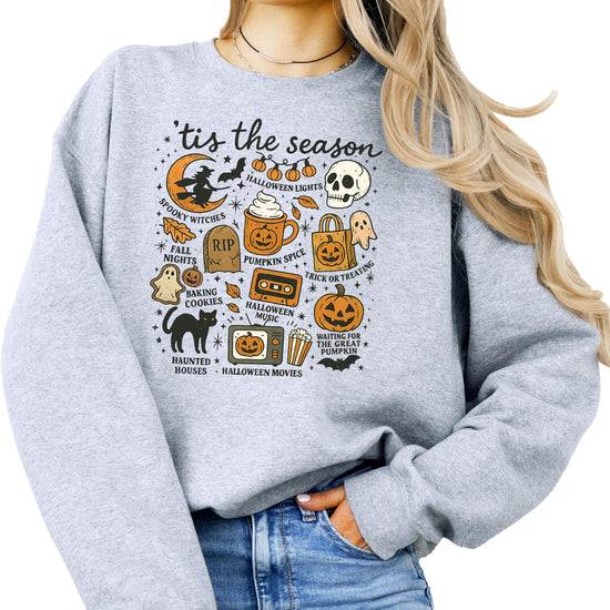 Flat lay of gray Halloween sweatshirt with pumpkin ghost design styled with fall accessories