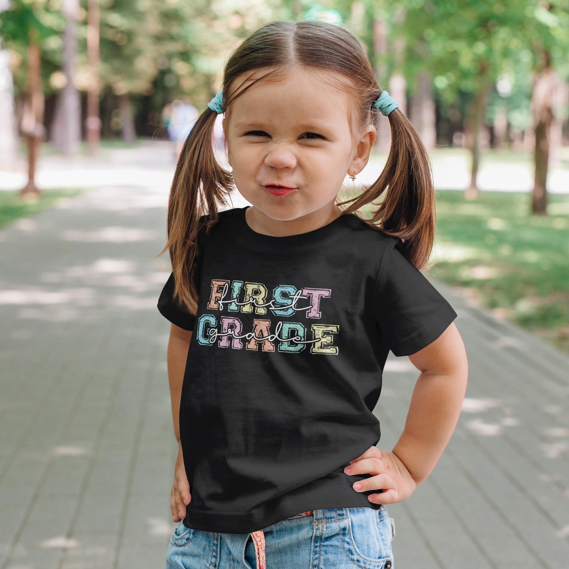 Close-up of 1st grade girls tee featuring vibrant pastel graphic lettering design