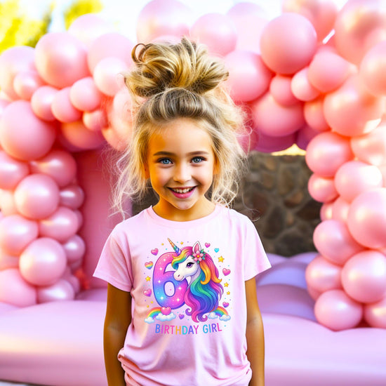 Flat lay of kids unicorn birthday graphic tee with bright rainbow colors and sparkly details