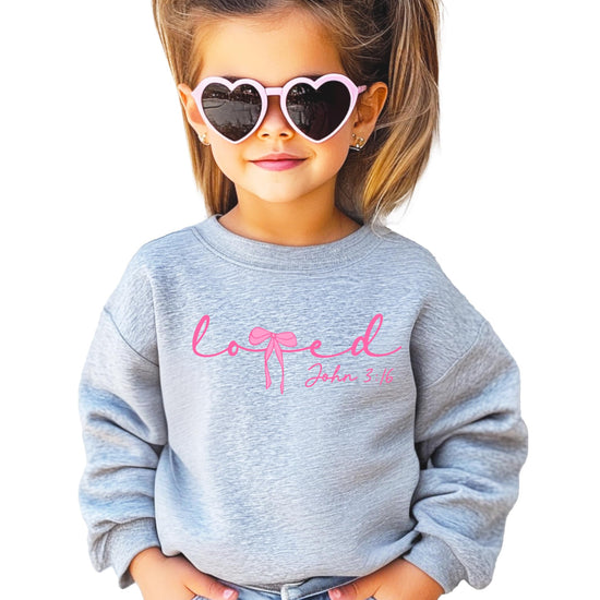 Front view of Loved John 3:16 Valentine's sweatshirt with pink bow detail on white fabric