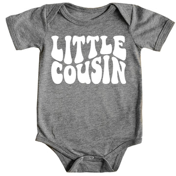 White Little Cousin retro bodysuit on mauve background with groovy lettering