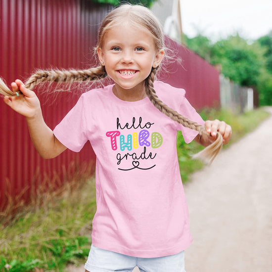 Third grade back to school shirt for kids laid flat showing full graphic design in pink