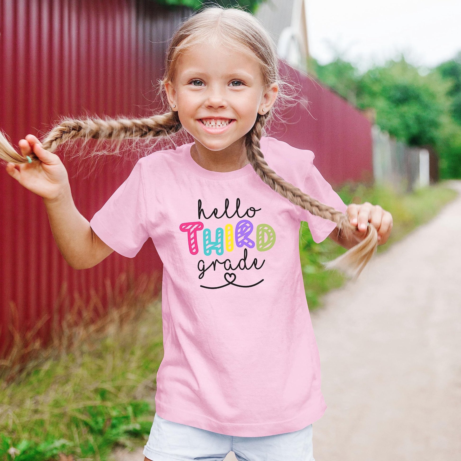 Third grade back to school shirt for kids laid flat showing full graphic design in pink