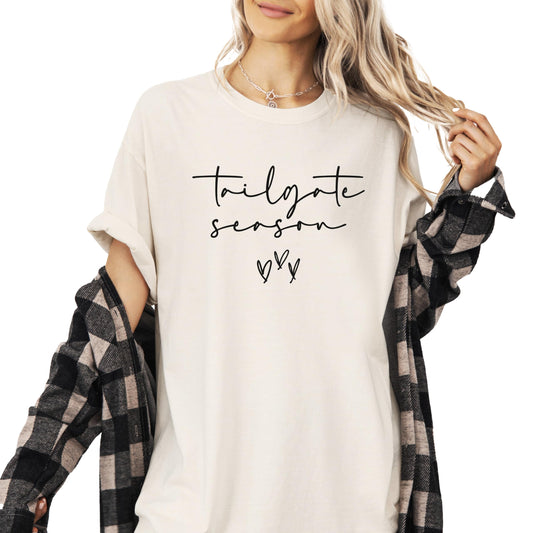 Flat lay of ivory Tailgate Season women's tee showing full shirt design