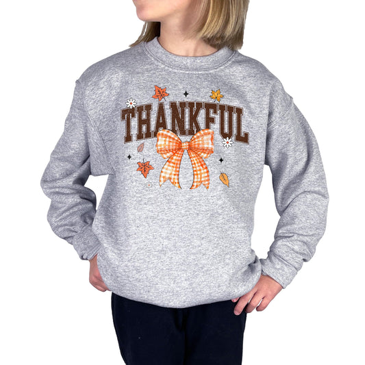 Close-up view of Thankful text with decorative orange bow and fall leaves design