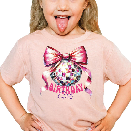 Side view of girls birthday tee with pink bow disco ball coquette print in natural color