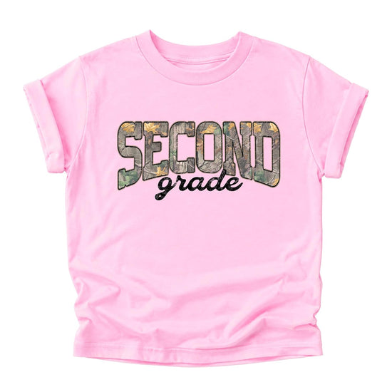 Girl wearing second grade camo tee in pink colorway with bold camo graphic lettering for first day of school