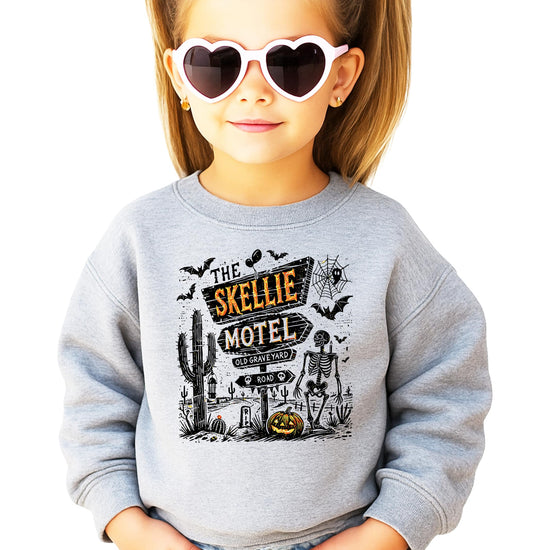 Close-up of The Skellie Hotel skeleton and haunted motel graphic print on soft crewneck sweatshirt