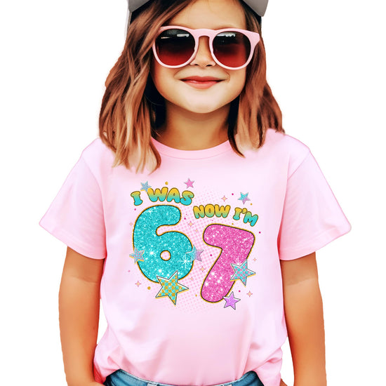 Close-up of glitter ink-printed 'I Was 6 Now I'm 7' design on pink youth t-shirt