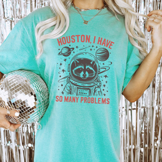 Detail shot of vibrant astronaut raccoon design on soft seafoam green t-shirt