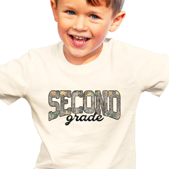 Close-up of woodland camo leaf print lettering on kids second grade back to school graphic tee