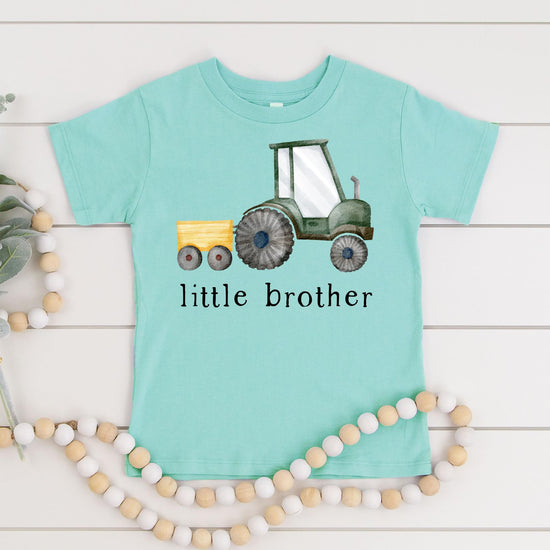 Detail shot of little brother tractor graphic print quality on natural bodysuit fabric