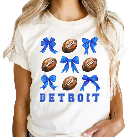 Women's natural color Detroit football graphic tee with girly footballs and coquette blue bows design