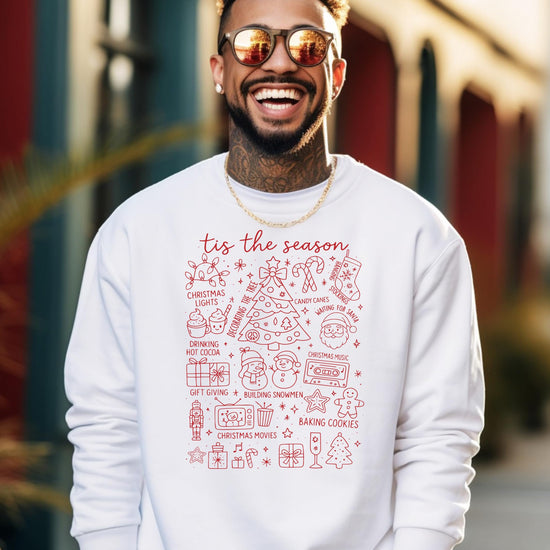 Close-up of 'Tis the Season holiday graphic print on white sweatshirt showing print quality