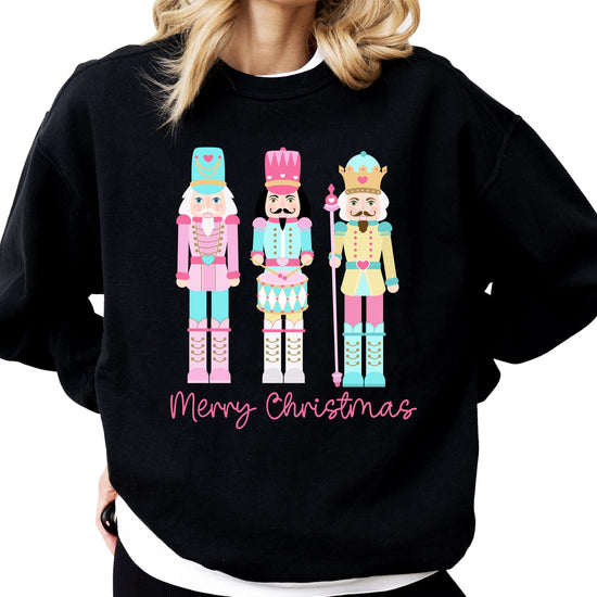 Pastel nutcracker Merry Christmas sweatshirt with colorful holiday design on black pullover