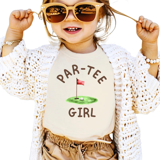 Girl wearing Par-Tee Girl golf birthday graphic tee in natural color