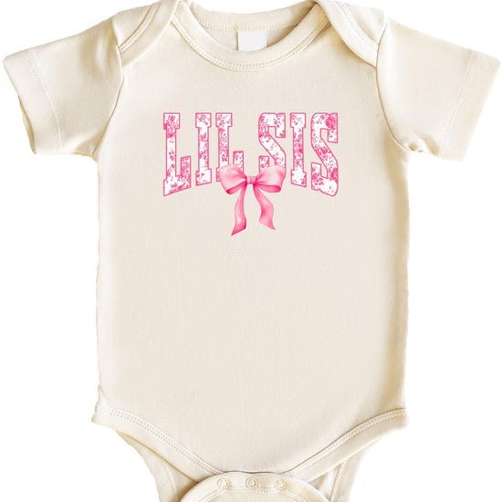 Close-up of floral graphic and pink bow design on a natural one-piece baby bodysuit