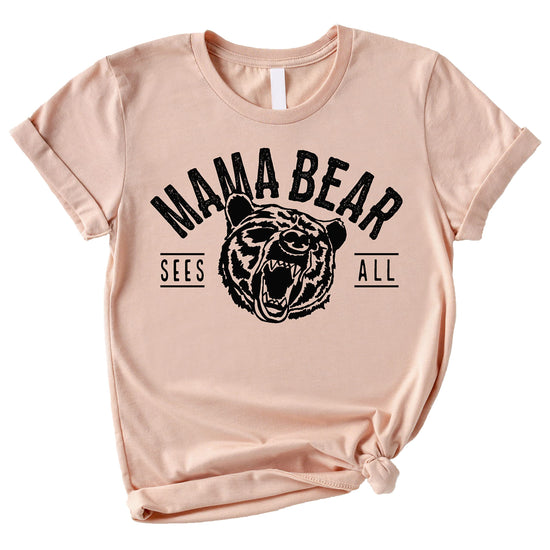 Peach Mama Bear Sees All shirt laid flat showing full graphic detail
