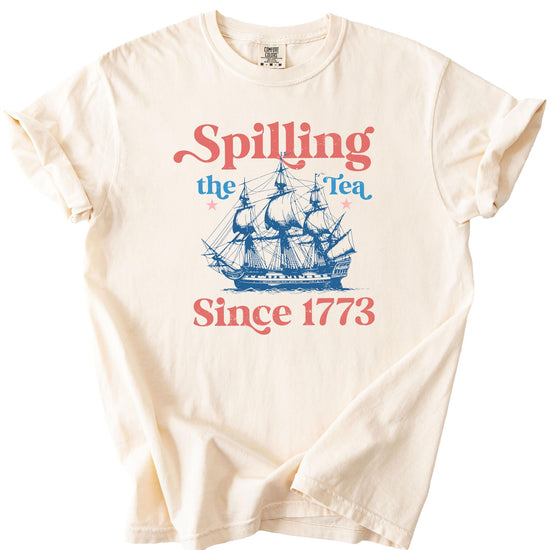 Flat lay of ivory Spilling The Tea Since 1773 shirt displaying full design