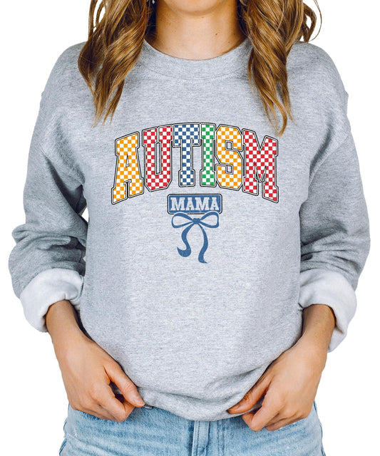 Close-up of bold multicolor checkered Autism Mama print on white sweatshirt