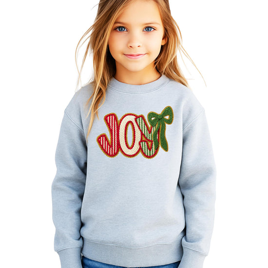 Side or styled view of women's festive JOY Christmas graphic sweatshirt pullover