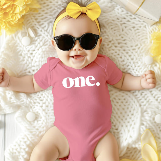 Detail shot of white Bold One print on mauve bodysuit for baby 1st birthday party outfit