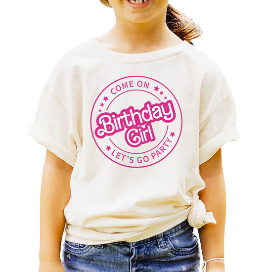 Pink retro graphic tee for kids reading Come On Birthday Girl Let's Go Party on a light background