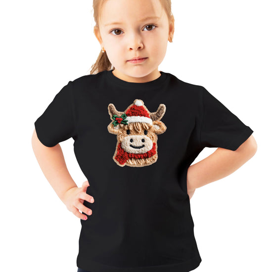 Flat lay of kids vintage red Christmas graphic tee with cow in Santa hat design