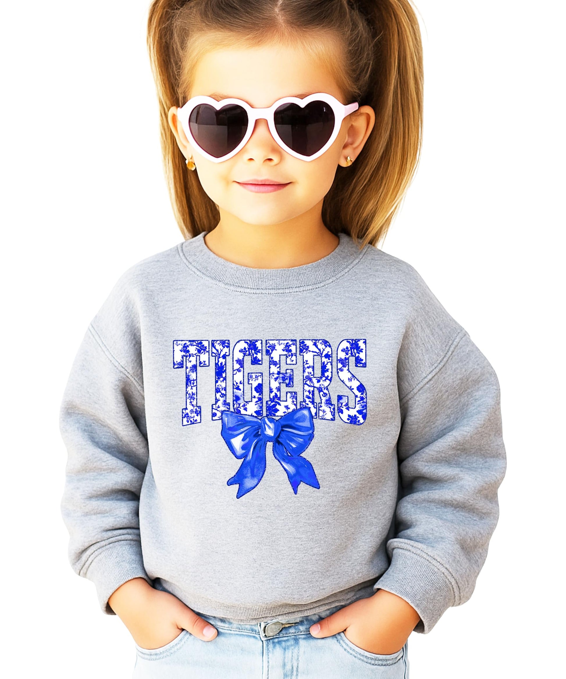 Close-up of Tigers blue floral print text with decorative bow graphic on sweatshirt