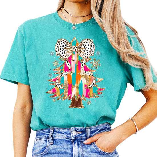 Close-up of faux glitter Christmas tree with dalmatian dot bow print on seafoam shirt