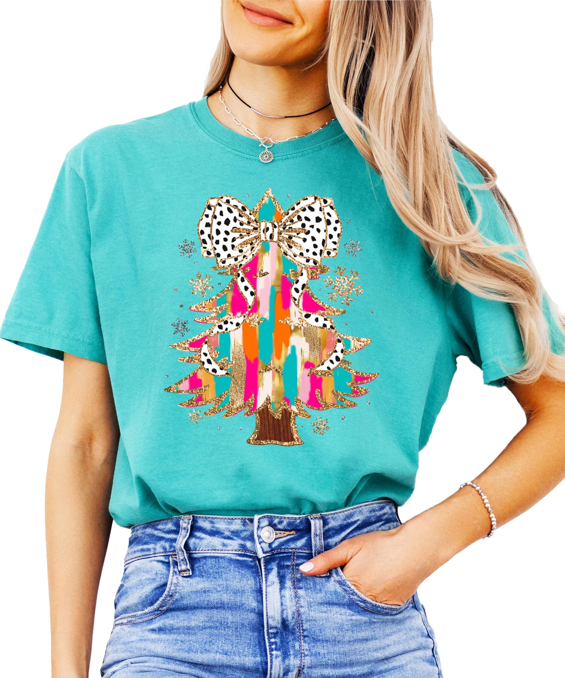 Close-up of faux glitter Christmas tree with dalmatian dot bow print on seafoam shirt